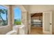 Bright bathroom featuring tile walls, a toilet, and a large window with a beach view at 2411 And 2407 Casey Key Rd, Nokomis, FL 34275
