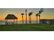 Idyllic beachfront scene with a charming tiki hut, swaying palm trees, and tranquil ocean views at 2411 And 2407 Casey Key Rd, Nokomis, FL 34275