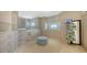 Walk-in closet with custom shelving, cabinets, and a comfortable ottoman at 2411 And 2407 Casey Key Rd, Nokomis, FL 34275
