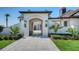 Elegant entryway with arched doorway, stone walkway, and lush landscaping at 2411 And 2407 Casey Key Rd, Nokomis, FL 34275