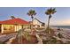 Charming beachfront home featuring lush landscaping, hammock, and serene ocean views at 2411 And 2407 Casey Key Rd, Nokomis, FL 34275