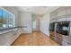 Bright laundry room with white cabinetry, farmhouse sink, herringbone floors, and stainless steel washer and dryer at 2411 And 2407 Casey Key Rd, Nokomis, FL 34275