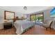 Comfortable bedroom with king bed, tiled floor and a sliding glass door that opens to a lush tropical patio at 2411 And 2407 Casey Key Rd, Nokomis, FL 34275