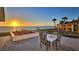 Inviting outdoor patio with dining set, lush lawn, and breathtaking ocean sunset views at 2411 And 2407 Casey Key Rd, Nokomis, FL 34275