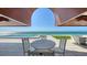 An outdoor patio boasts a white table and seating with stunning ocean views at 2411 And 2407 Casey Key Rd, Nokomis, FL 34275