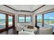 Bright sitting room with ocean views and comfortable seating around a center ottoman table at 2411 And 2407 Casey Key Rd, Nokomis, FL 34275