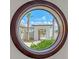 Porthole window view framing the lush landscaping and architecture at 2411 And 2407 Casey Key Rd, Nokomis, FL 34275