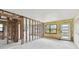 Living room undergoing renovation with exposed framing, peeling paint, and unfinished floors, offering a blank canvas for customization at 2506 Mabry St, Tampa, FL 33618