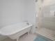 Bright bathroom featuring a clawfoot tub and a glass-enclosed shower with tiled walls at 2921 W El Prado Blvd, Tampa, FL 33629