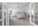 Bright bedroom featuring wood floors, a chandelier, and sliding mirrored closet doors at 2921 W El Prado Blvd, Tampa, FL 33629