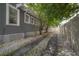 Driveway of a well maintained home with white gravel, mature trees, lush landscaping, and a white picket fence at 2920 W El Prado Blvd, Tampa, FL 33629