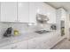 Detailed view of the modern kitchen with white cabinets, marble backsplash, and stainless steel appliances at 2921 W El Prado Blvd, Tampa, FL 33629