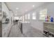 Well-lit kitchen featuring a center island with marble countertop, stainless steel appliances, and white cabinetry at 2921 W El Prado Blvd, Tampa, FL 33629