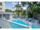 Relaxing backyard pool area with lounge chairs, tropical landscaping, and charming pool house with bright blue accents at 2921 W El Prado Blvd, Tampa, FL 33629