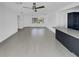 Bright living room with modern ceiling fan and ceramic tile flooring, leading to the kitchen at 318 41St Ave, St Pete Beach, FL 33706