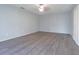 Spacious living room featuring modern gray flooring, light-colored walls, a ceiling fan and bright natural light at 3571 Edington Way, Palm Harbor, FL 34685