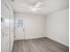 Bedroom with wood-look floors, ceiling fan, and white door leading to a small outdoor area at 4928 W Gandy Blvd # G203, Tampa, FL 33611