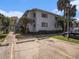 Two-story condo building with neutral exterior, landscaped grounds, and designated parking spaces at 4928 W Gandy Blvd # G203, Tampa, FL 33611