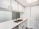 Bright kitchen featuring white cabinetry, stainless steel appliances, quartz countertops, and a modern faucet at 4928 W Gandy Blvd # G203, Tampa, FL 33611