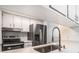 Modern kitchen with white cabinets, stainless steel appliances, and a quartz countertop at 4928 W Gandy Blvd # G203, Tampa, FL 33611