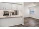 Well-lit kitchen area featuring white cabinets, stainless steel appliances, and a view into the living area at 4928 W Gandy Blvd # G203, Tampa, FL 33611