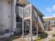 Exterior wooden staircase providing access to upper-level units with railings and landing at 4928 W Gandy Blvd # G203, Tampa, FL 33611