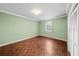 Empty bedroom featuring parquet floors, light green walls, a window, and a closet with louvered doors at 5010 Bayshore Blvd # 9, Tampa, FL 33611