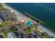 Aerial view of a community clubhouse, pool, and pier overlooking the waterfront and a lush surrounding landscape at 5231 Beach Se Dr # A, St Petersburg, FL 33705
