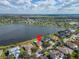 Aerial view of lakefront home featuring a pool, lush landscaping, and serene water views at 5325 Sandy Shell Dr, Apollo Beach, FL 33572