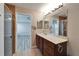 Bathroom with shower, vanity, sink, and view into bedroom with wood floors at 5325 Sandy Shell Dr, Apollo Beach, FL 33572