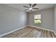 Bedroom featuring wood flooring, ceiling fan, base trim and window at 5325 Sandy Shell Dr, Apollo Beach, FL 33572
