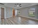 A large bedroom with a ceiling fan and two windows offering lots of natural light, with wood-style floors at 5325 Sandy Shell Dr, Apollo Beach, FL 33572