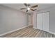 Bedroom with wood-look flooring, ceiling fan, and double door closet at 5325 Sandy Shell Dr, Apollo Beach, FL 33572