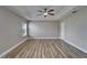 Bright bedroom with wood-style floors, tray ceiling, ceiling fan, and natural light from a window at 5325 Sandy Shell Dr, Apollo Beach, FL 33572