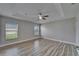 Spacious bedroom with wood-style floors, a ceiling fan, and plenty of natural light from two windows at 5325 Sandy Shell Dr, Apollo Beach, FL 33572