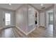 Interior hallway with wood-look floors, neutral walls, and doors leading to various rooms, including laundry at 5325 Sandy Shell Dr, Apollo Beach, FL 33572