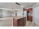 Kitchen island with wood cabinets and stone countertop, leading into a spacious open-plan living area at 5325 Sandy Shell Dr, Apollo Beach, FL 33572
