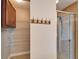 Shower with a glass door, and adjacent shelving and towel hooks at 5325 Sandy Shell Dr, Apollo Beach, FL 33572