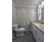 Bathroom featuring white vanity, commode, and granite countertop at 5403 Comanche St, Zephyrhills, FL 33542