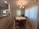 Cozy dining area with a chandelier and natural light, adjacent to the kitchen at 5403 Comanche St, Zephyrhills, FL 33542