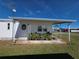 Single-story home featuring a covered patio and well-maintained landscaping at 5403 Comanche St, Zephyrhills, FL 33542