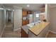 Well-lit kitchen with wood cabinets, laminate flooring, and a pass-through to the dining area at 5403 Comanche St, Zephyrhills, FL 33542