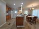 Open kitchen featuring wood cabinets, laminate flooring, and a dining area with natural light at 5403 Comanche St, Zephyrhills, FL 33542