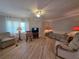 Bright living room with a ceiling fan and large windows, creating a comfortable living space at 5403 Comanche St, Zephyrhills, FL 33542