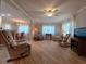 Bright living room with wood floors, a ceiling fan, and two comfortable recliner chairs at 5403 Comanche St, Zephyrhills, FL 33542