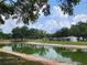 Scenic pond area with lush greenery, trees, and ample space for relaxation at 5403 Comanche St, Zephyrhills, FL 33542