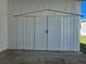 Exterior storage shed with double doors and a peaked roof for added storage at 5403 Comanche St, Zephyrhills, FL 33542