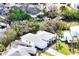 Aerial view of the white home, with landscaped lawn, canal dock, and screened-in pool at 809 30Th E Ct, Bradenton, FL 34208