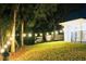 A nighttime view of a spacious backyard with lush green grass and decorative string lights at 809 30Th E Ct, Bradenton, FL 34208