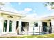 Exterior view of white home with a pool secured by black fencing and accented by string lights at 809 30Th E Ct, Bradenton, FL 34208
